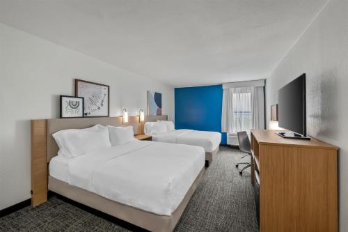 a hotel room with a large bed and a desk at Spark by Hilton Spring Lake Fayetteville in Spring Lake