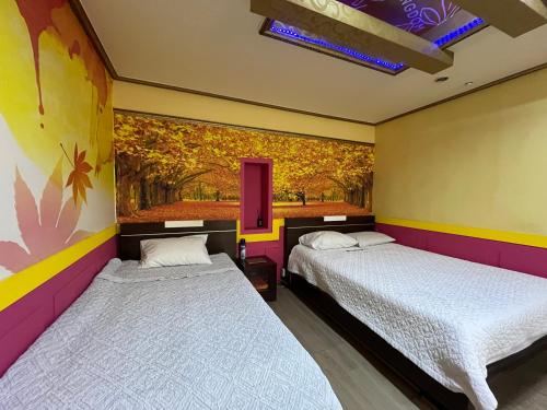 ポハンにあるKingdom Motelのカラフルな壁の客室内のベッド2台