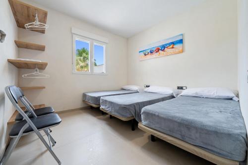 a room with two beds and a chair in it at Trabucador in Camarles