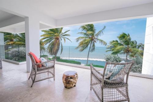 a room with a view of the ocean and palm trees at Hodges Bay Resort & Spa, an HQ Luxury Resort & Residences in Saint Johnʼs
