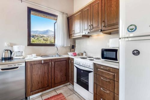 a kitchen with wooden cabinets and a sink and a window at Villa Panorama in Levktron