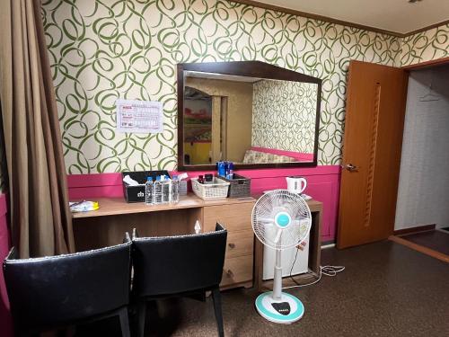 ポハンにあるKingdom Motelの鏡付きのデスク、ファンが備わる客室です。