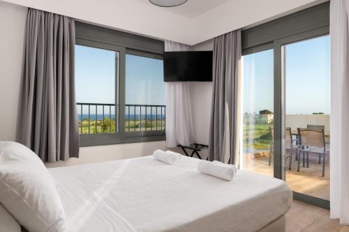 a bedroom with a bed and a view of a balcony at Villa Vasaltis & Selestitis in Gennadi