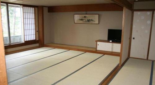 a room with a room with a television and a room with a room at Hotel Tokoen in Yonago