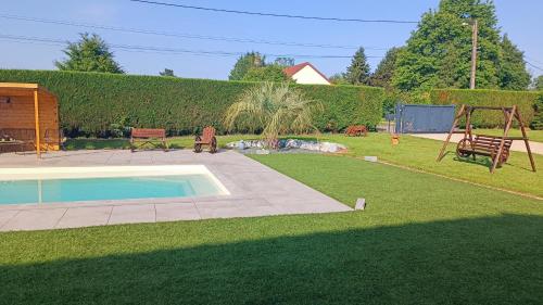 une cour avec une piscine et une aire de jeux dans l'établissement Au nid d'hirondelles, à La Celle-sous-Gouzon