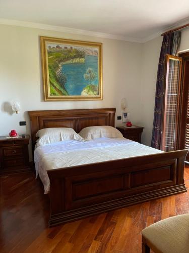 a bedroom with a large bed with a painting on the wall at Fenix Villa in Noicattaro