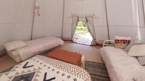 une chambre avec trois lits et une fenêtre dans l'établissement Au nid d'hirondelles, à La Celle-sous-Gouzon