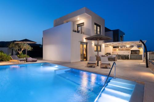 a villa with a swimming pool at night at Villa Vasaltis & Selestitis in Gennadi