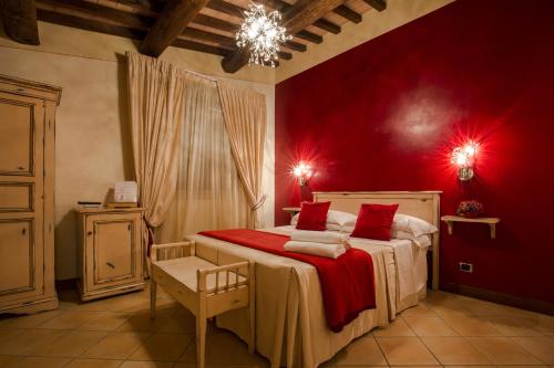 PianelloにあるIl Melograno Agriturismo & SPAの赤い壁のベッド付きの赤いベッドルーム