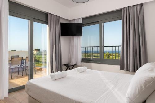 a bedroom with a bed and a balcony with windows at Villa Vasaltis & Selestitis in Gennadi