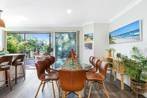 a dining room with a table and chairs at Treetops on Seabreeze in Toormina