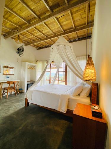 a bedroom with a bed with a mosquito net at Cozy bliss homestay sidemen in Sidemen