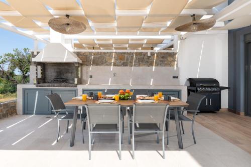 a kitchen with a table and chairs in a kitchen at Villa Vasaltis & Selestitis in Gennadi