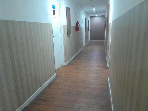 a corridor of a hallway with wooden floors and a door at Smart Inn at Aeropolis Residence in Teko