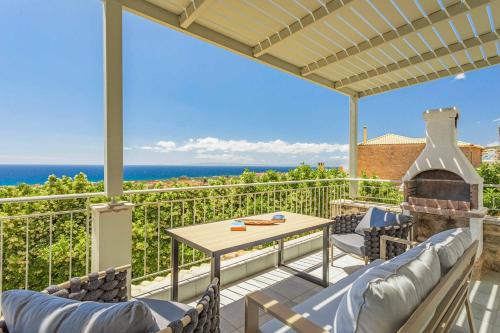 a patio with a table and chairs and a fireplace at Villa Levanda Elia in Pírgos