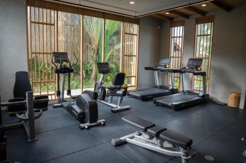a gym with several treadmills and machines in a room at JATI Koh Russey in Sihanoukville