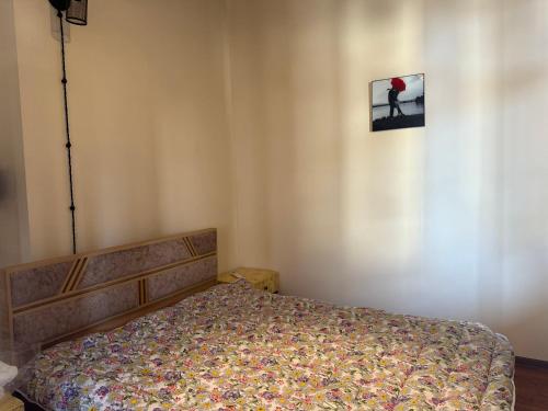 a bedroom with a bed and a picture on the wall at Guesthouse Anaberika in Velistsʼikhe