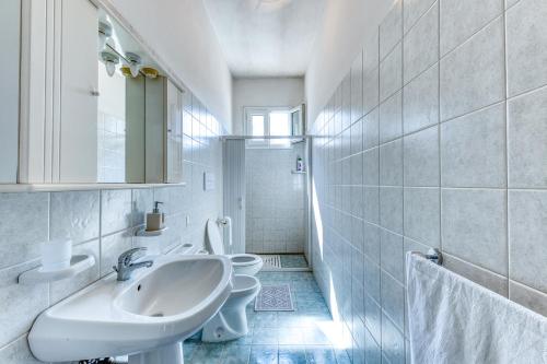 a white bathroom with a sink and a toilet at Casa Saulle - Costruzione Tipica in Felline