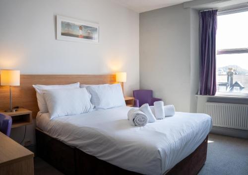 a hotel room with a bed with towels on it at The Seafront Hotel by Compass Hospitality in Llandudno