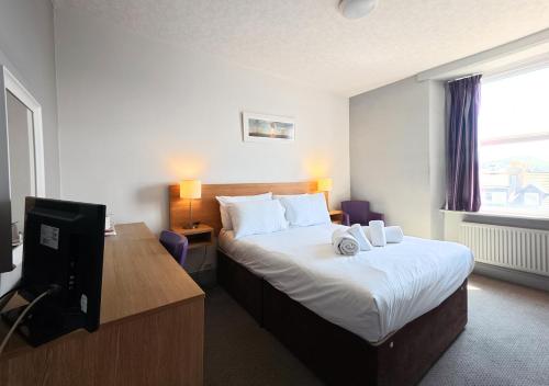 a hotel room with a bed and a television at The Seafront Hotel by Compass Hospitality in Llandudno