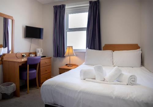 a hotel room with a bed with towels on it at The Seafront Hotel by Compass Hospitality in Llandudno