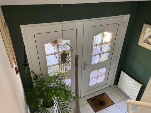 a hallway with a white door and a plant at ZWITSCHERNEST Stilvolle helle Ferienwohnung Gästezimmer Monteurwohnung für 1 bis 6 Personen 3 Zimmer 60 qm in Itzehoe