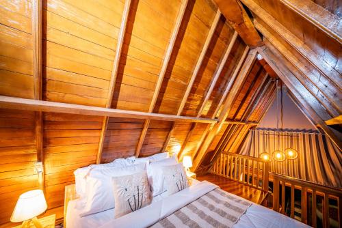 a bed in a room with a wooden ceiling at Asasta Kintamani Villa in Kubupenlokan