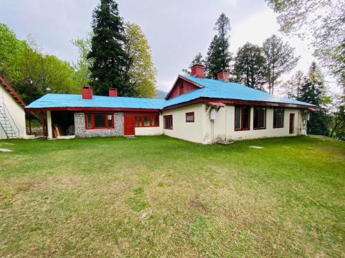 a house with a blue roof on a yard at Bilour House Main Dunga Gali Bazar, nathiagali in Dunga Gali