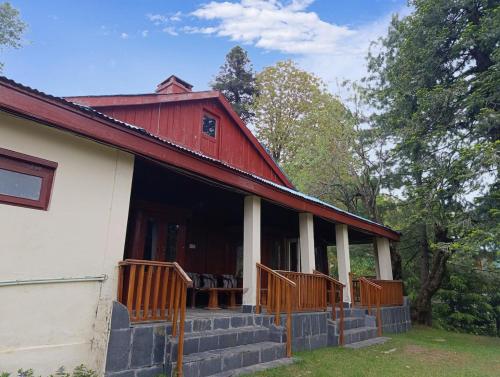 a red and white house with a porch at Bilour House Main Dunga Gali Bazar, nathiagali in Dunga Gali