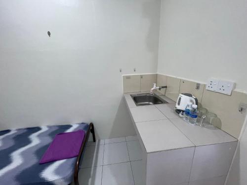 a small kitchen with a sink and a counter at Bilik 3 Katil Single Aircond Pekan in Pekan