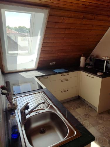 a kitchen with a sink and a large window at FeWo Sonnenblick Rammingen in Rammingen