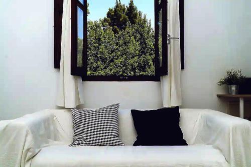 a white couch with two pillows in a living room at Casa La Temprana in Montán