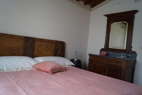 a bedroom with a pink bed and a mirror at Il Borghetto di Carra in Talla