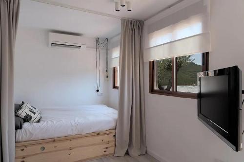 a bedroom with a bed and a tv and a window at Casa La Temprana in Montán