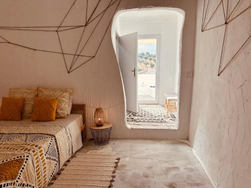 a bedroom with a bed and a large window at Muralhas do frade in São Pedro do Corval