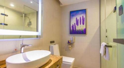 a white bathroom with a sink and a mirror at Lavande Hotels Suzhou Railway Station in Suzhou