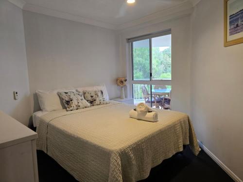 a bedroom with a bed with a towel on it at Fairways Golf & Beach Retreat Bribie Island in Woorim