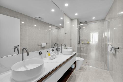 a bathroom with two sinks and a shower at The Gallery Residences Broadbeach - Official Listing in Gold Coast