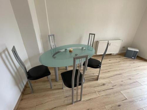 a glass table and chairs in a room at Schönes Apartment mit Infrarot Sauna und Balkon in Plauen