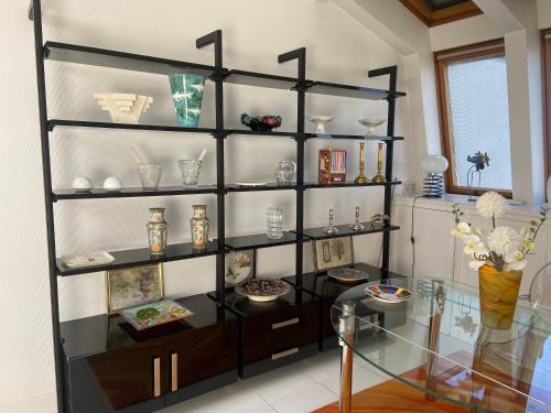 une étagère avec des vases et des assiettes dans l'établissement La Rose des vents, à La Rochelle