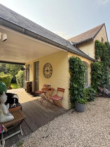 a porch of a house with a table and chairs at Le Jardin Des Secrets "Gites et chambres à louer" in Namur