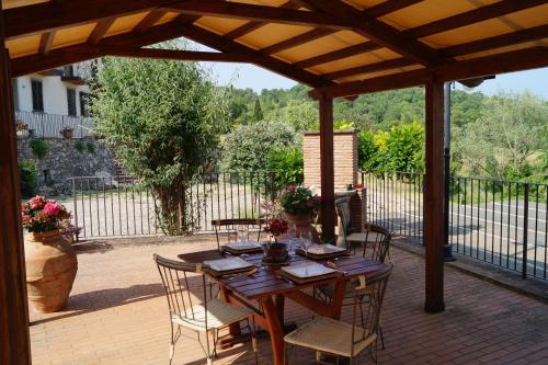 a wooden table and chairs on a patio at Il Borghetto di Carra in Talla