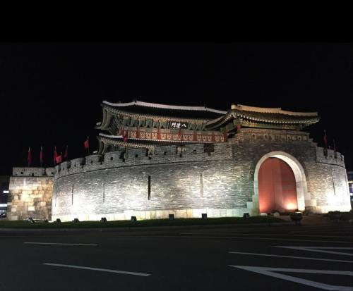 a large building with a red door at night at 스칼렛 스테이 수원역 - Scarlett Stay at Suwon Station in Suwon