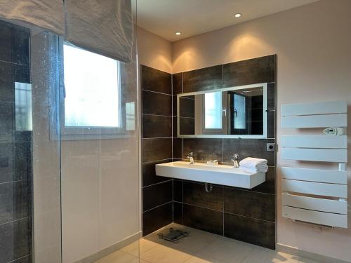 une salle de bain avec un lavabo et un miroir dans l'établissement Belle villa climatisée avec piscine, à Tornac