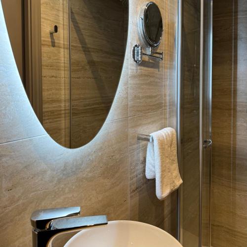 a bathroom with a toilet and a shower with a mirror at Palazzo De La Sengle Boutique Hotel in Senglea