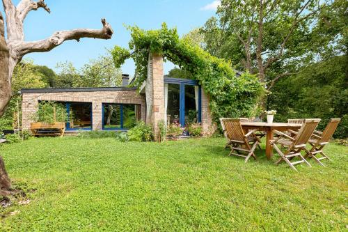 a house with a table and chairs in the yard at Villa Isabelle in Aywaille