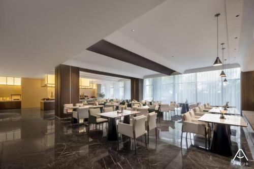 a restaurant with tables and chairs in a building at Atour Hotel Cultural Centre, Pinghu Economic Development Zone in Pinghu
