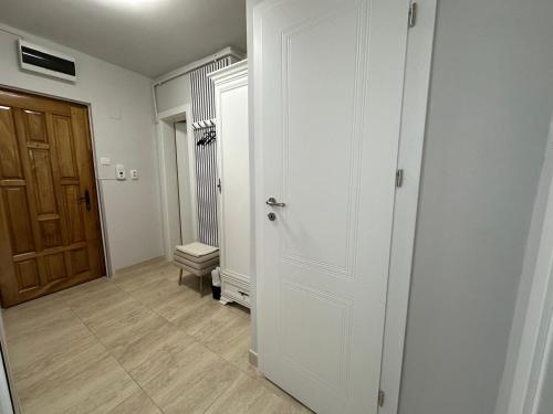 an empty hallway with a white door and a wooden door at Studio PANORAMIC with Balcony and Parcul Unirii view in Alba Iulia