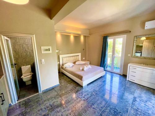a bedroom with a bed and a bathroom with a toilet at Octopus in Vasiliki