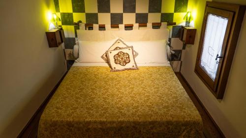 a small bed in a room with a window at Il Borghetto di Carra in Talla